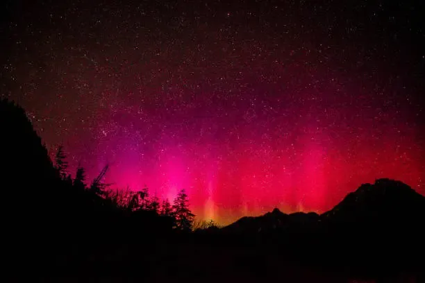 Un'incantevole aurora boreale tinge di rosso il cielo delle Dolomiti: uno spettacolo naturale tra scienza, cultura e patrimonio UNESCO